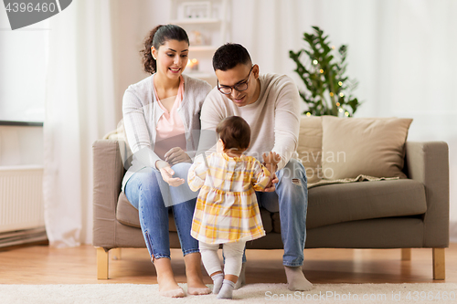 Image of happy family with baby daughter at home