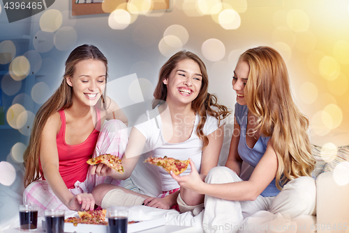 Image of happy friends or teen girls eating pizza at home