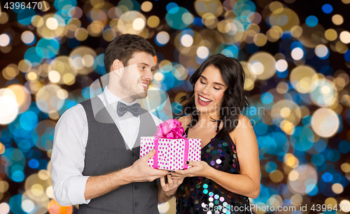 Image of happy couple with gift box at birthday party