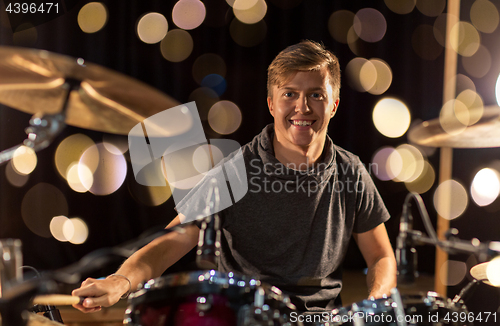 Image of male musician playing drum kit at concert