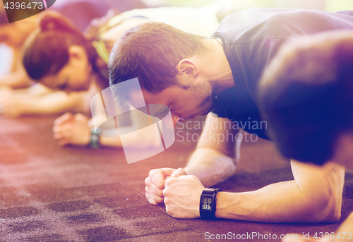 Image of man with heart-rate tracker exercising in gym