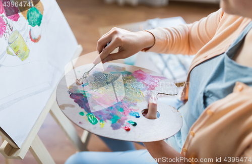Image of artist with palette knife painting at art studio