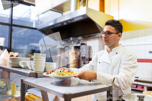 Image of chef with dish on plate at kebab shop