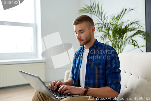 Image of man with laptop working at office