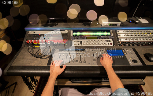 Image of man using mixing console in music recording studio