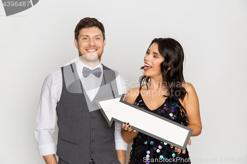 Image of happy couple with big arrow at party