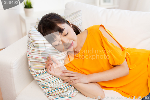 Image of young asian woman sleeping on sofa at home