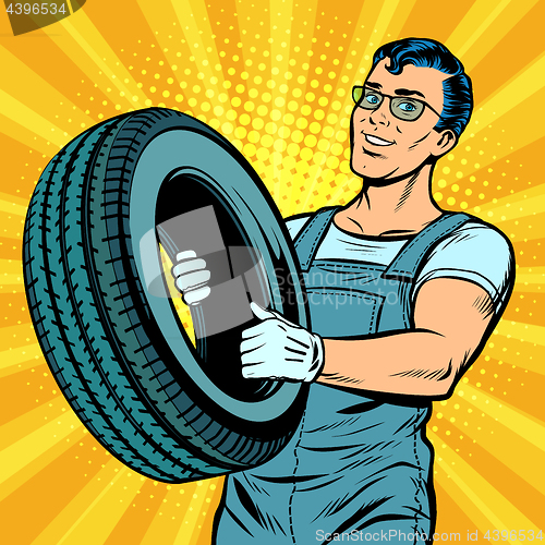Image of Male car mechanic with wheel
