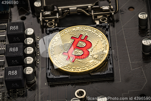 Image of Gold Bit Coin BTC coins on the motherboard. Bitcoin is a worldwi