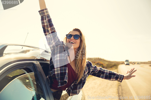 Image of happy girl looking out the car window