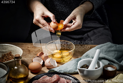 Image of female hands is braking eggs 