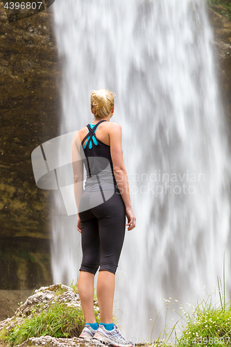 Image of Active woman looking at Pericnik waterfall in Vrata Valley in Triglav National Park in Julian Alps, Slovenia.