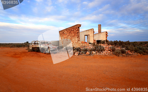 Image of Crumbling stone home and rusty car