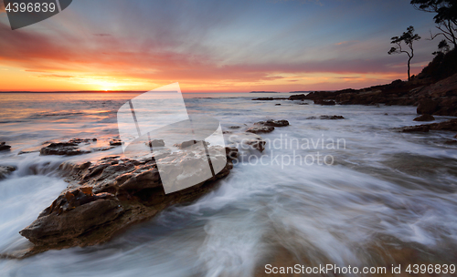 Image of Sunrise over the Bay with ocean over rocks