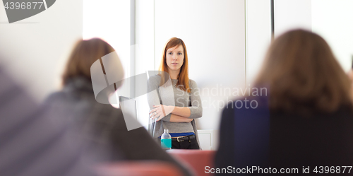 Image of Woman giving presentation in lecture hall at university.