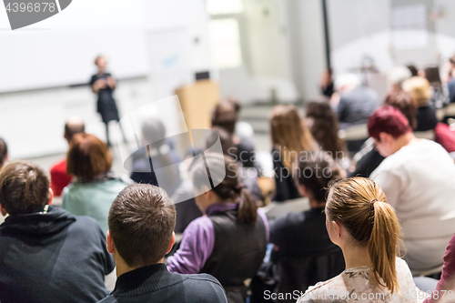 Image of Woman giving presentation in lecture hall at university.