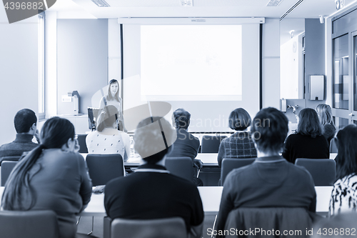 Image of Woman giving presentation in lecture hall at university.