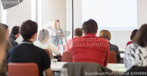 Image of Woman giving presentation in lecture hall at university.