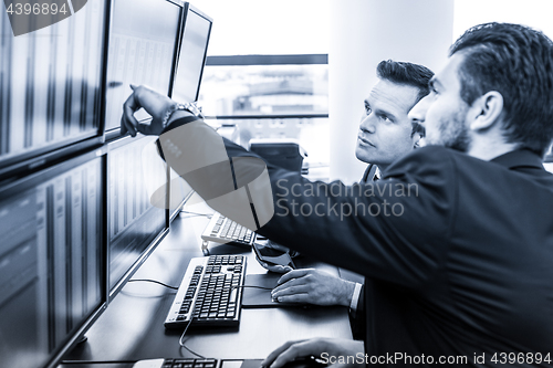 Image of Stock traders looking at market data on computer screens.