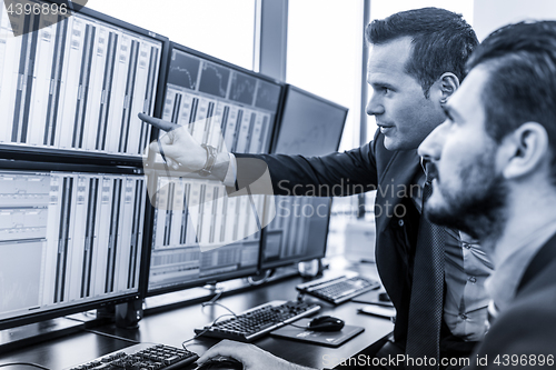 Image of Stock traders looking at market data on computer screens.