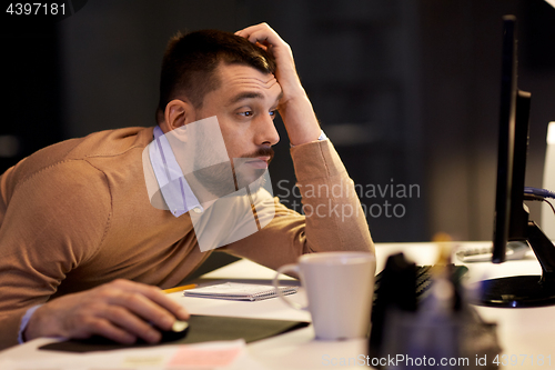 Image of tired man on table at night office