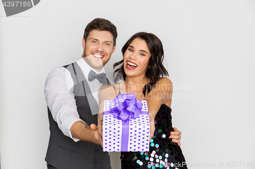 Image of happy couple with gift box at birthday party