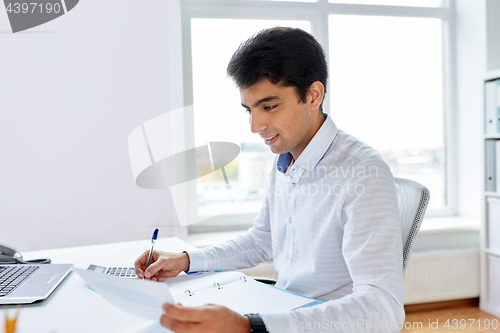 Image of businessman working with papers at office