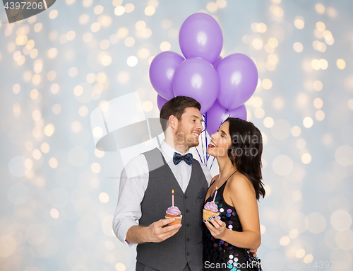 Image of happy couple with balloons and cupcakes at party