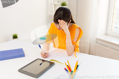 Image of asian student girl with tablet pc learning at home