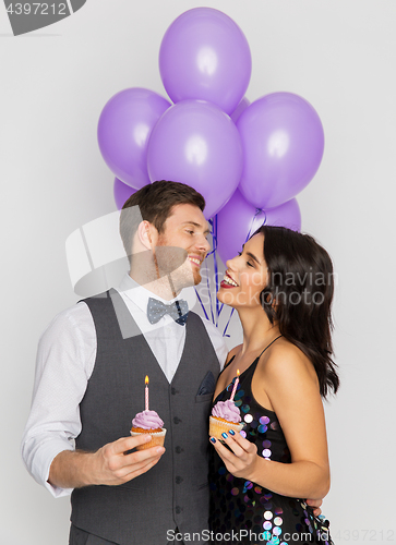 Image of happy couple with balloons and cupcakes at party