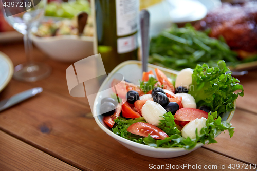 Image of vegetable salad with mozzarella on wooden table