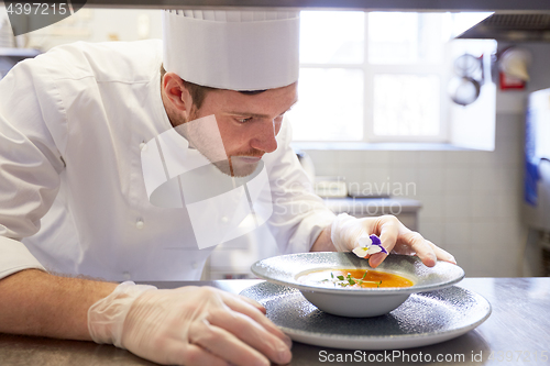 Image of happy male chef cooking food at restaurant kitchen