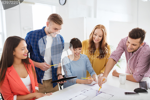 Image of creative team with blueprint working at office