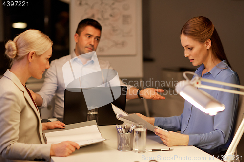 Image of business team with laptop working late at office