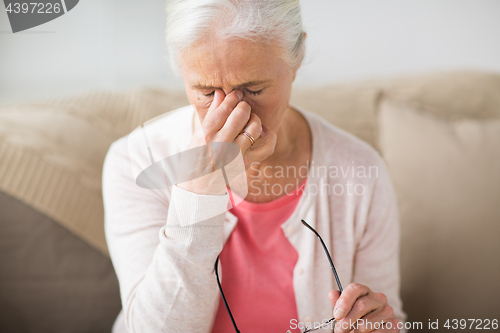 Image of senior woman with glasses having headache at home