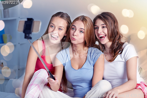 Image of teen girls with smartphone taking selfie at home