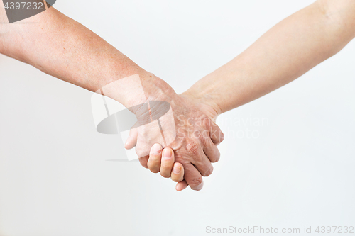 Image of close up of senior and young woman holding hands