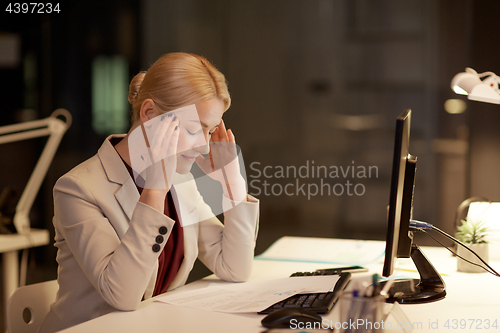 Image of businesswoman with computer at night office