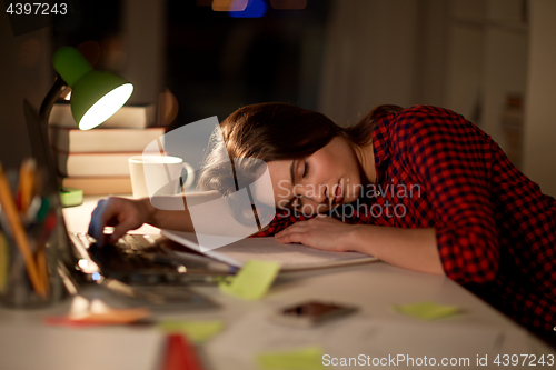 Image of student or woman sleeping on table at night home