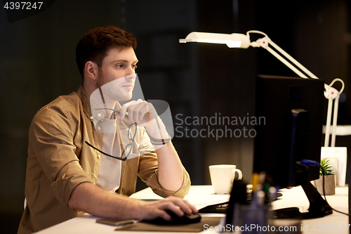 Image of man with computer working late at night office