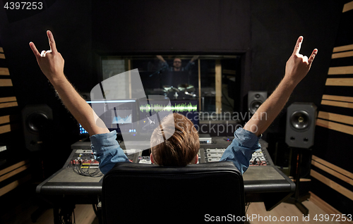 Image of man at mixing console in music recording studio