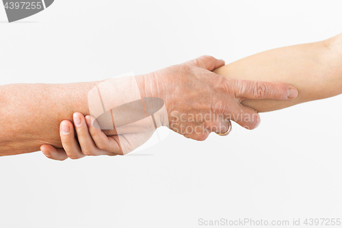 Image of close up of senior and young woman holding hands