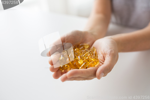 Image of hands holding cod liver oil capsules