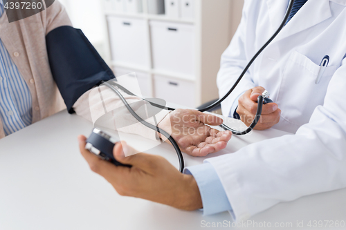 Image of doctor with tonometer and senior woman at hospital