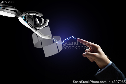 Image of robot and human hand connected by lightning