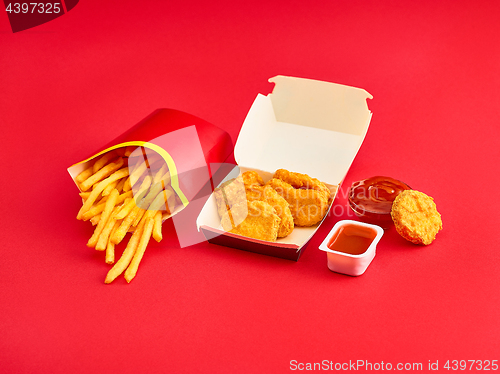 Image of chicken nuggets and french fries on red background
