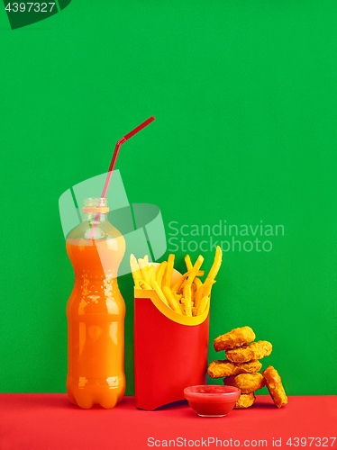 Image of chicken nuggets and french fries on red background