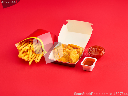 Image of chicken nuggets and french fries on red background