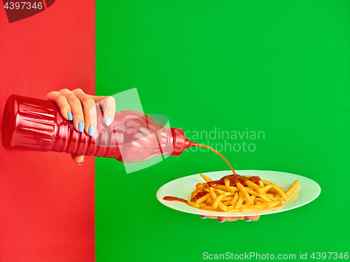 Image of Young woman with plate of french fries potato with ketchup