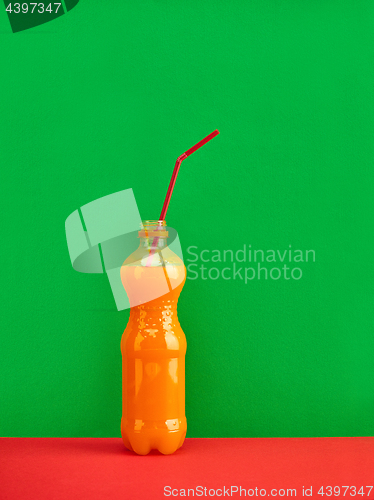 Image of Glass of fresh orange juice on red background